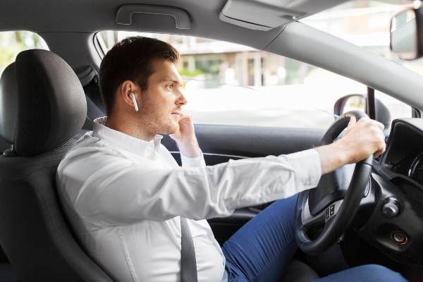 Driver with wireless earphones having a distracting conversation
