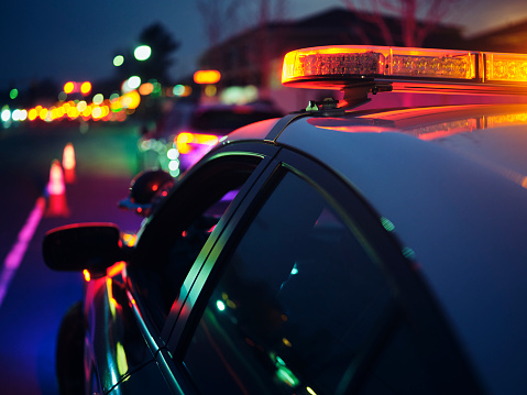 A police car stopping a vehicle at night.