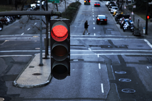 Red street light hanging above a city intersection