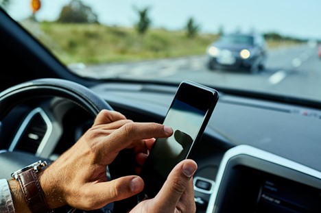 Closeup of a motorist texting while driving