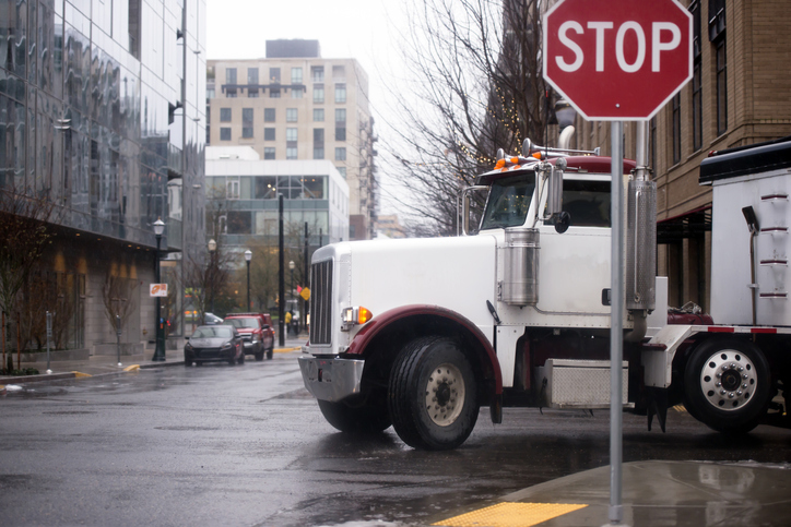 Tractor trailer at an intersection on a rainy day